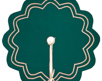 Puede incluir: Una falda de árbol verde oscuro con un borde festoneado y un borde bordado en rosa claro. La falda tiene un tallo blanco con una bola redonda y blanca en la parte superior y un lazo en la parte inferior. La falda está diseñada para rodear la base de un árbol de Navidad.