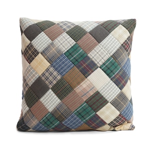 Könnte beinhalten: Ein quadratisches Kissen mit Patchwork-Muster aus verschiedenen karierten Stoffen in Grün, Blau, Braun und Beige.