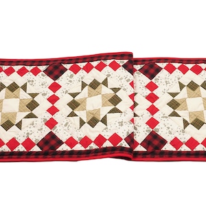 May include: A red, black, and white quilted table runner with a star pattern. The runner is made of fabric with a plaid design.