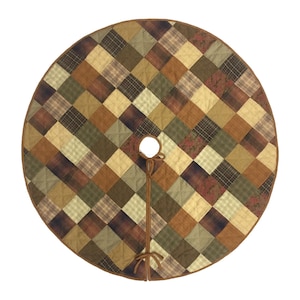 Peut inclure: Une jupe de sapin de Noël ronde et matelassée avec un motif patchwork dans des tons de brun, vert et beige. La jupe est bordée d'une bande brune et se ferme avec un nœud.