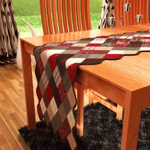 May include: A red, brown, and cream checkered table runner with a scalloped edge. The runner is on a wooden table with two chairs.