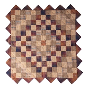 May include: A patchwork quilt with a brown, tan, and blue plaid pattern. The quilt has a scalloped edge and is made of cotton fabric.