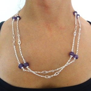Peut inclure: Un collier en chaîne argent avec plusieurs brins et des perles d'améthyste violettes.