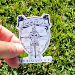 May include: A white sticker with a black and white illustration of a knight in armor. The text "Put on the full armor of God" is at the top of the sticker. The text "Ephesians 6:10" is at the bottom of the sticker.