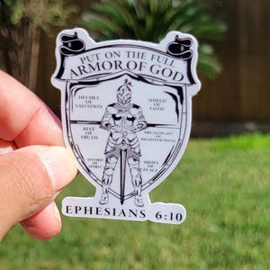 May include: A white sticker with a black and white illustration of a knight in armor. The text "PUT ON THE FULL ARMOR OF GOD" is at the top of the sticker. The text "EPHESIANS 6:10" is at the bottom of the sticker.