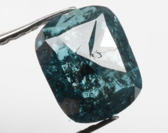 May include: A dark blue, faceted, rough cut diamond with a rectangular shape.