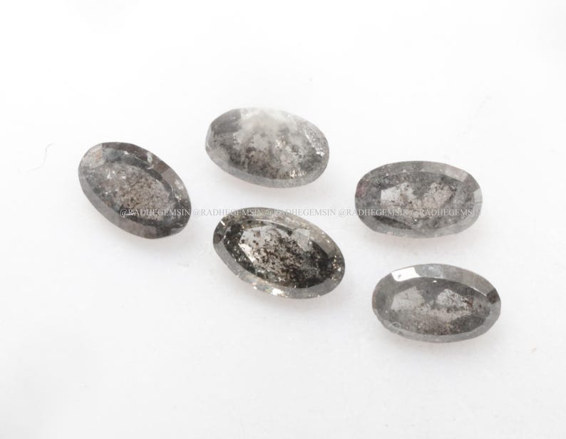 Pode incluir: Cinco diamantes cinzentos de forma oval com inclus&otilde;es pretas. Os diamantes est&atilde;o soltos e prontos para serem engastados em joias.