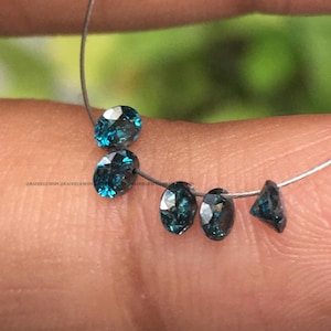 May include: Five loose blue gemstones on a silver wire. The gemstones are round and oval shaped.