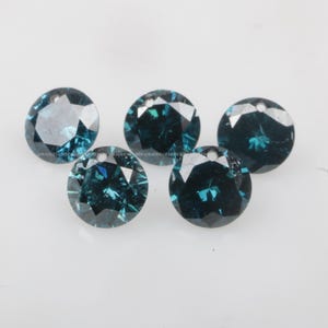 May include: Five round, teal blue gemstones with a faceted cut. The gemstones are arranged in a semi-circle on a white surface.