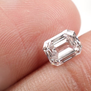 Pu&ograve; includere: Una pietra preziosa di diamante di taglio smeraldo rettangolare trasparente.
