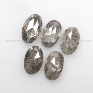 Pode incluir: Cinco diamantes brutos de cor cinza de forma oval e facetados. Os diamantes t&ecirc;m um acabamento &aacute;spero e natural.