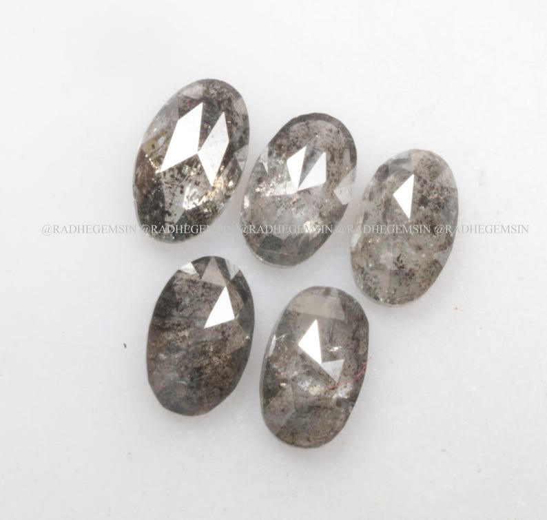 Pode incluir: Cinco diamantes brutos de cor cinza de forma oval e facetados. Os diamantes t&ecirc;m um acabamento &aacute;spero e natural.