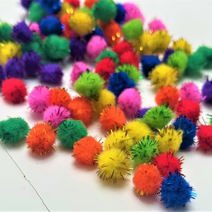 Könnte beinhalten: Eine Sammlung bunter Pompons mit Glitzerakzenten. Die Pompons sind in verschiedenen Farbtönen von Rosa, Blau, Grün, Gelb, Orange und Lila.