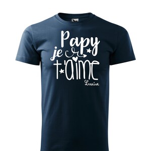 Peut inclure: Un t-shirt bleu marine avec un texte blanc qui dit "Papy je t'aime" avec un cœur et des étoiles. Le texte "Louise" est écrit sous le texte principal.