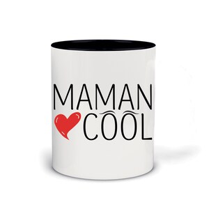 Peut inclure: Mug en céramique blanche avec un bord noir. Le mug a un cœur rouge et du texte noir qui dit "Maman Cool".