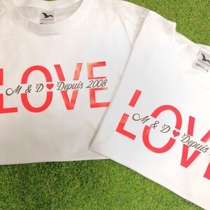 Peut inclure: Deux t-shirts blancs avec le mot "LOVE" imprimé en lettres rouges. Les t-shirts ont le texte "M & D Depuis 2008" imprimé en noir.