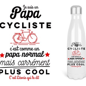 Peut inclure: Une gourde isotherme blanche avec un design noir et rouge. Le texte sur la gourde est "Je suis un Papa Cycliste c'est comme un papa normal mais carrément PLUS COOL C'est Léonie qui le dit".