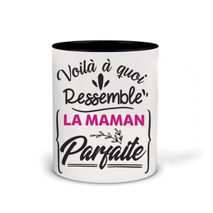 Op de afbeelding: Witte keramische mok met een zwarte rand. De mok heeft zwarte tekst met de tekst "Voila a quoi ressemble LA MAMAN Parfaite" met een roze "Parfaite".