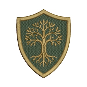 Pode incluir: Um emblema bordado em forma de escudo com um fundo verde-escuro e um desenho de árvore na cor dourada centralizado na borda. A árvore tem raízes e galhos visíveis, e todo o emblema é contornado com um fio grosso na cor dourada.