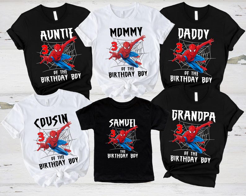 May include: A collection of black and white t-shirts featuring a Spider-Man graphic. Each shirt has a different text: "AUNTIE", "MOMMY", "DADDY", "COUSIN", "SAMUEL", and "GRANDPA". The shirts also include "OF THE BIRTHDAY BOY".