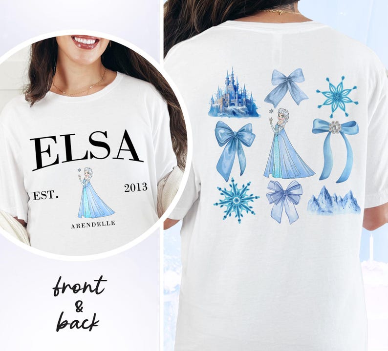 May include: White t-shirt featuring the name "ELSA" in black, with "EST. 2013 ARENDELLE" below a cartoon image of a princess. The back of the shirt displays blue bows, snowflakes, a castle, and a princess.