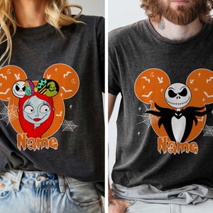 Op de afbeelding: Twee zwarte T-shirts met een Mickey Mouse-silhouetontwerp met Jack Skellington en Sally uit The Nightmare Before Christmas. De shirts hebben de tekst "Name" onder het ontwerp.