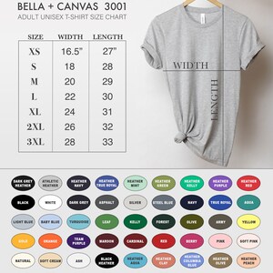 Pu&ograve; includere: Una tabella delle taglie per t-shirt unisex per adulti Bella + Canvas 3001. La tabella mostra le misure di larghezza e lunghezza in pollici per le taglie XS a 3XL. Una t-shirt grigia &egrave; mostrata appesa a un appendiabiti.