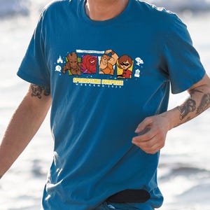 Peut inclure: Un t-shirt bleu avec un motif de personnages de l'univers cinématographique Marvel. Le motif comprend Groot, Thor et Gamora. Le texte "Springtime Surprise Weekend 2023" est imprimé sous le motif.