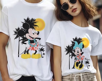 May include: White t-shirts with a Mickey Mouse and Minnie Mouse design. Mickey Mouse is wearing a lei and red shorts. Minnie Mouse is wearing a blue bow and red shorts. Both characters are standing in front of palm trees and a yellow sun. The text "Hawaii" is printed on both shirts.