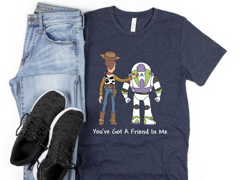 Puede incluir: Una camiseta azul marino con una imagen de dibujos animados de Woody y Buzz Lightyear de Toy Story. El texto "You've Got A Friend In Me" est&aacute; impreso debajo de la imagen.