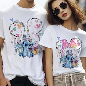 K&ouml;nnte beinhalten: Wei&szlig;e T-Shirts mit einem Stitch-Cartoon-Design. Das Design umfasst ein Schloss, Feuerwerk und Mickey Mouse Ohren. Die Stitch-Figur ist blau und die Ohren haben farbige Akzente.