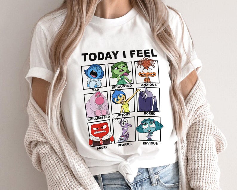 Pu&ograve; includere: Maglietta bianca con una grafica dei personaggi del film Inside Out. La grafica dice "Oggi mi sento" e ha una griglia di nove quadrati con ogni personaggio che rappresenta un'emozione diversa: Triste, Disgustato, Ansioso, Imbarcato, Gioioso, Annoiato, Arrabbiato, Paura, Invidioso.