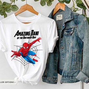 Op de afbeelding: Wit T-shirt met een rode en blauwe Spiderman-afbeelding en de tekst "Amazing Nani of the Birthday Boy".
