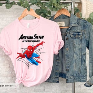 Op de afbeelding: Roze T-shirt met een Spiderman-afbeelding en de tekst "Amazing Sister of the Birthday Boy".