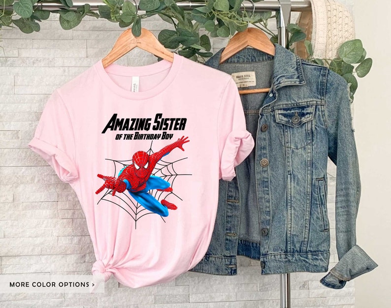 Op de afbeelding: Roze T-shirt met een Spiderman-afbeelding en de tekst "Amazing Sister of the Birthday Boy".