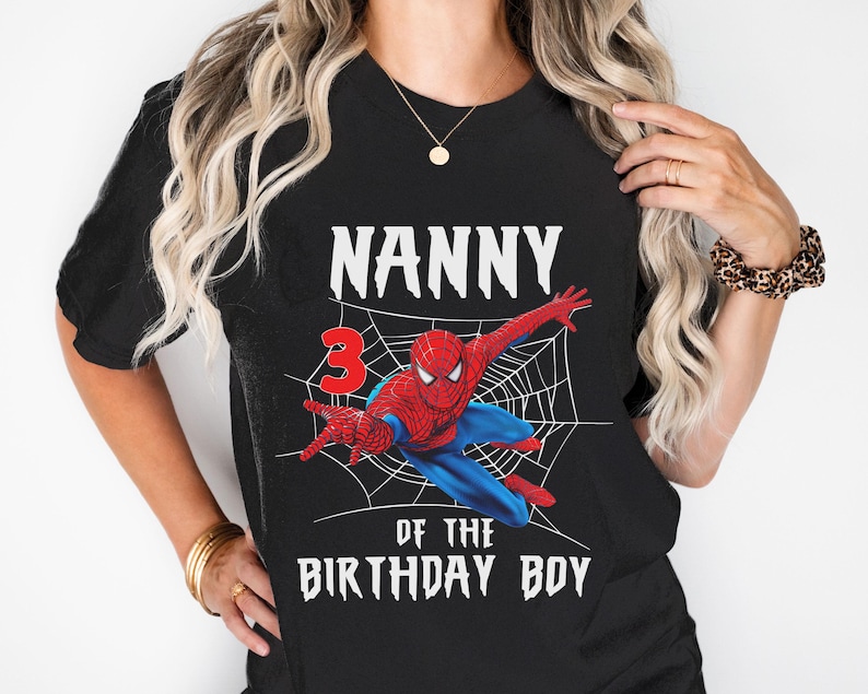 Puede incluir: Camiseta negra con un gr&aacute;fico de Spider-Man en una telara&ntilde;a, el n&uacute;mero 3 y el texto "Nanny of the Birthday Boy" en blanco. El superh&eacute;roe es rojo y azul.