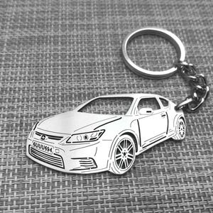 May include: A silver metal keychain featuring a detailed outline of a car with the license plate "5UUU594".