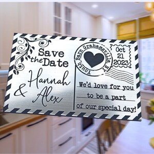 Pode incluir: Cart&atilde;o de prata para guardar a data com texto preto e um gr&aacute;fico de cora&ccedil;&atilde;o preto. O texto diz "Save the Date Hannah & Alex" e "Barn Grahamsville, NY Oct 21, 2023" e "We'd love for you to be a part of our special day!"