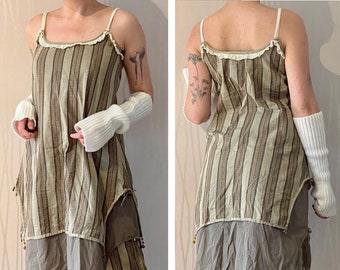 May include: A striped, beige and brown dress with a layered skirt and a ruffled neckline. The dress has a relaxed fit and is made of a lightweight fabric.