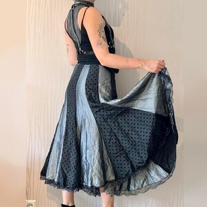 May include: A black and silver skirt with a polka dot pattern and a lace trim. The skirt is flowing and has a layered design.
