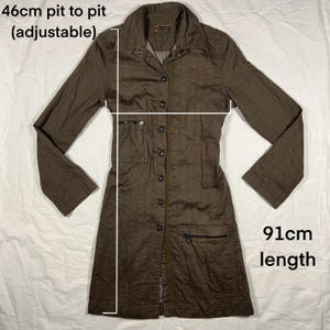 May include: A brown long-sleeved button-up shirt with a collar and pockets. The shirt is 46cm pit to pit (adjustable) and 91cm in length.