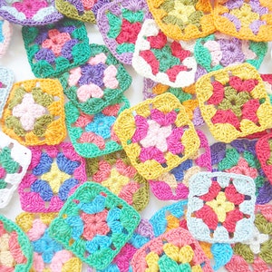 Pode incluir: Uma cole&ccedil;&atilde;o de quadrados de av&oacute; de croch&ecirc; em v&aacute;rias cores, incluindo rosa, verde, amarelo, azul e roxo.