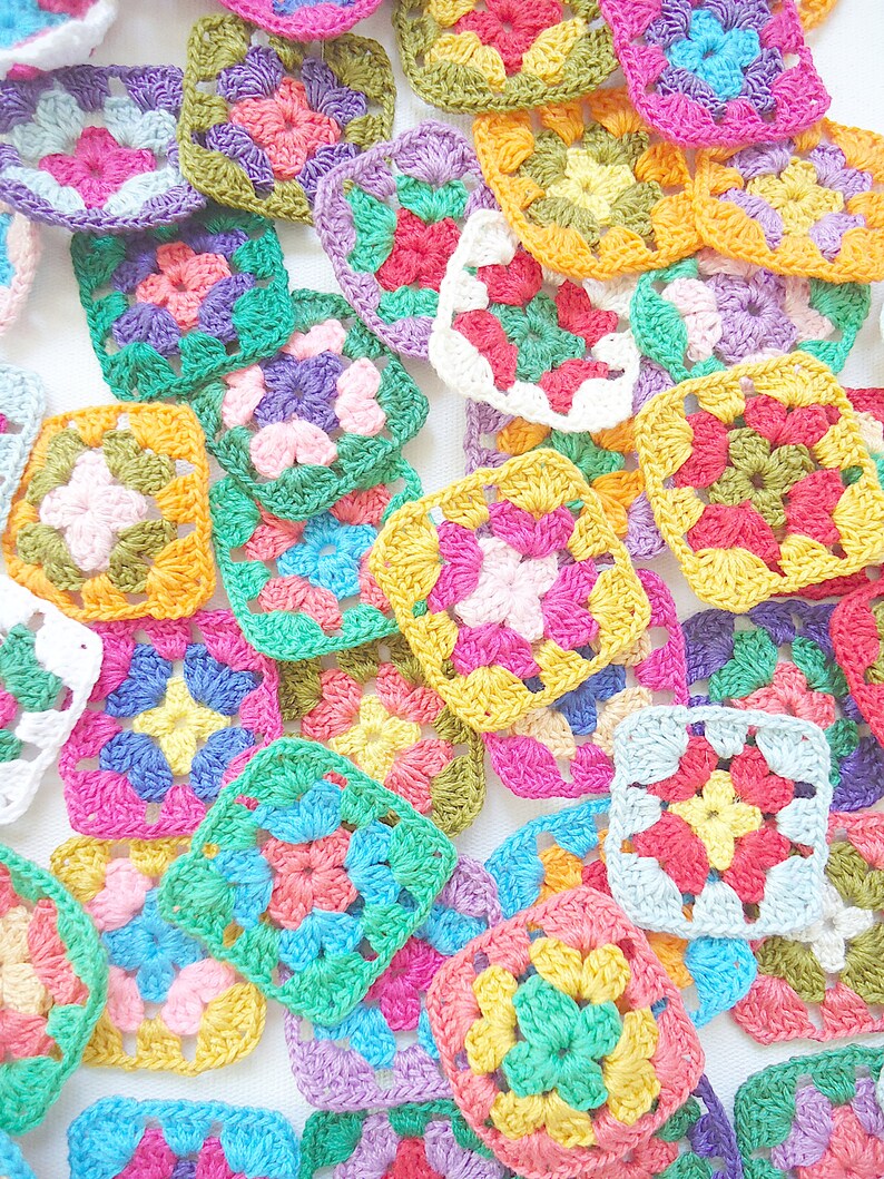 Pode incluir: Uma cole&ccedil;&atilde;o de quadrados de av&oacute; de croch&ecirc; em v&aacute;rias cores, incluindo rosa, verde, amarelo, azul e roxo.