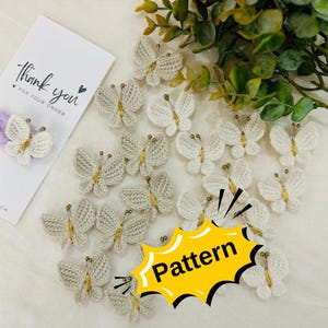 Könnte beinhalten: Eine Sammlung gehäkelter weißer Schmetterlings-Haarklammern mit goldenen Akzenten. Die Schmetterlinge sind in einem Muster auf einer weißen Oberfläche angeordnet. Der Text "Pattern" ist in Gelb auf weißem Hintergrund geschrieben.