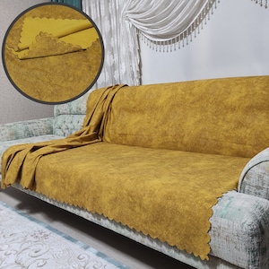 May include: A mustard yellow sofa with a matching throw blanket. The sofa has a textured fabric and a scalloped edge.
