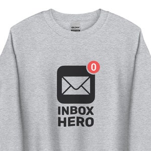 May include: A grey sweatshirt with a black graphic of an email icon with a red notification bubble that says "0" and the text "INBOX HERO".