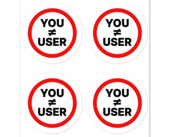 May include: Four round stickers with a red circle and white background. The text inside the circle reads "YOU != USER" in black.