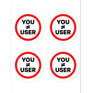 May include: Four round stickers with a red circle and white background. The text inside the circle reads "YOU != USER" in black.