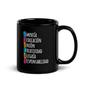 May include: Black ceramic mug featuring the word "EDUCAR" in colourful letters. The word is an acronym for "Empatía, Dedicación, Unión, Creatividad, Alegría, Responsabilidad" in white text. The mug has a large handle.