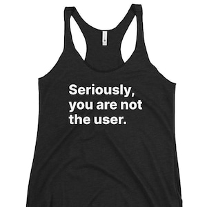 Può includere: Canotta grigio scuro con la scritta bianca "Seriously, you are not the user." La canotta ha uno scollo tondo e un design senza maniche.